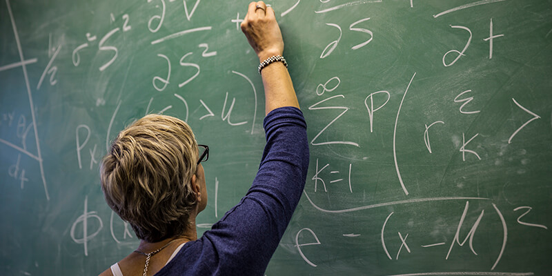 Math teacher at chalkboard