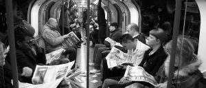 Subway riders reading newspapers